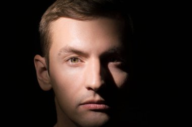 Siyah arka planda bir adamın portresi.