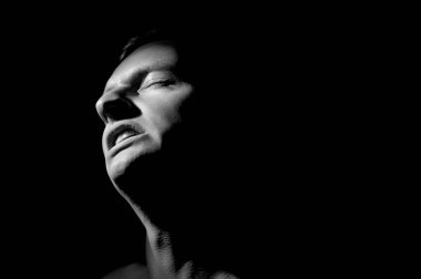 Siyah arka planda bir adamın portresi.