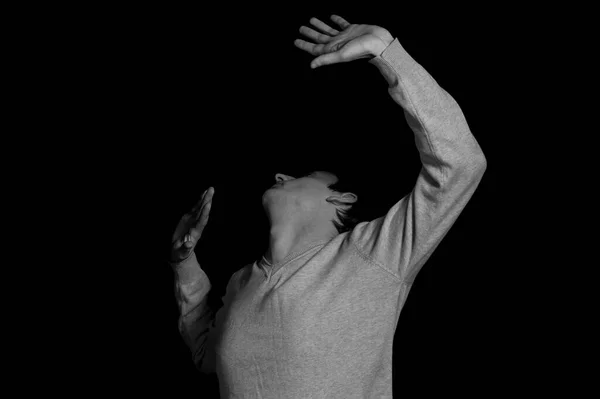 young man on a black background in a dramatic expressive pose