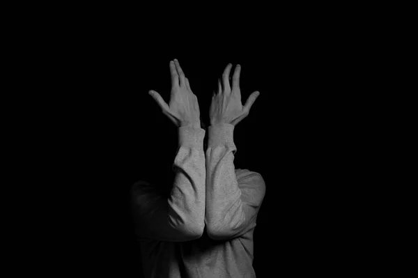 young man on a black background in a dramatic expressive pose