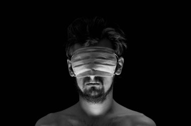 Siyah arka planda bir adamın portresi, gözlerinde bir maske.