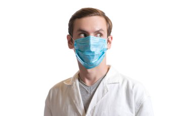 Tek kullanımlık maske takan ve beyaz arka planda sağlık ceketi giyen bir adamın portresi.