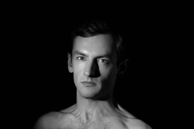 Siyah arka planda bir adamın dramatik portresi