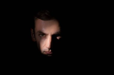 Siyah arka planda bir adamın dramatik portresi