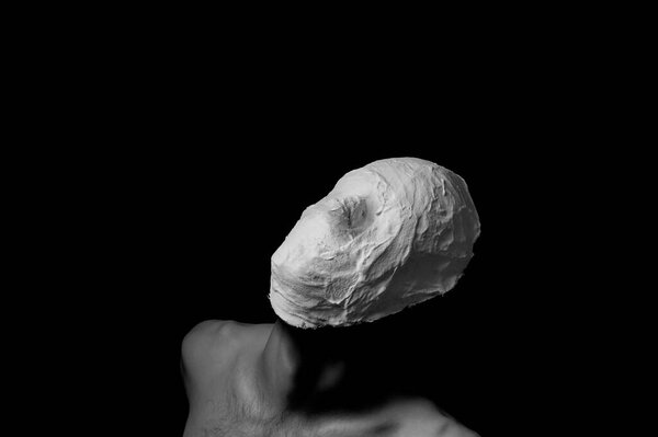 black and white photo of a man in a plaster mask
