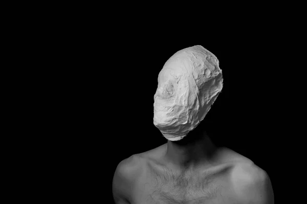 black and white photo of a man in a plaster mask