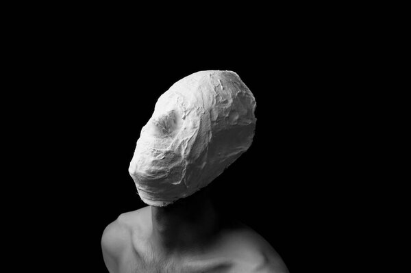 black and white photo of a man in a plaster mask