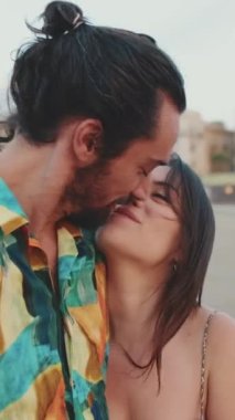 Yeni evliler sahilde birbirlerine sarılıp öpüşüyorlar.