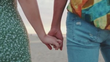 Deniz altyapısında el ele tutuşan genç bir çift. Arka plan