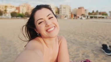 Mutlu genç kadın komik suratlar yapıyor ve selfie çekiyor.