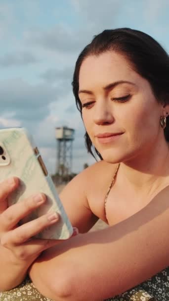 Video Vertical Cerca Mujer Joven Sentada Playa Arena Usando Teléfono — Vídeos de Stock