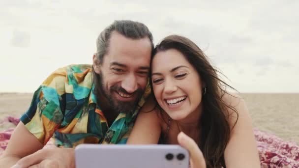 Ευτυχισμένο Ζευγάρι Χαλαρώνοντας Στην Παραλία Κάνοντας Βιντεοκλήση Στο Κινητό Τηλέφωνο — Αρχείο Βίντεο