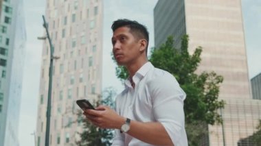 İş merkezinin yanında oturan genç işadamı cep telefonuna mesaj yazıyor.