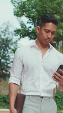 Genç iş adamı, modern binanın arka planında yürüyor.