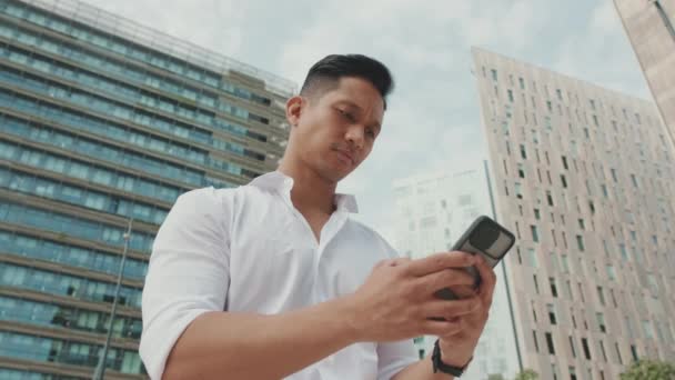 Mladý Podnikatel Psaní Smartphone Zatímco Stojí Obchodní Čtvrti — Stock video