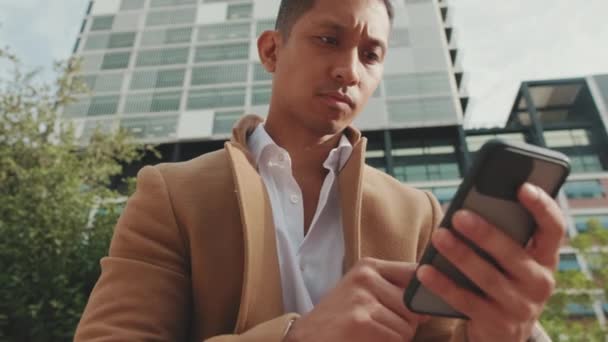 Yakından Bej Ceketli Genç Işadamı Sokakta Bankta Oturuyor Cep Telefonuyla — Stok video