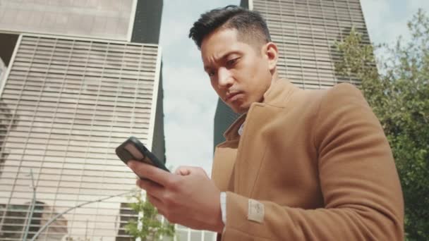 Yakından Bej Ceketli Genç Işadamı Sokakta Bankta Oturuyor Cep Telefonuyla — Stok video