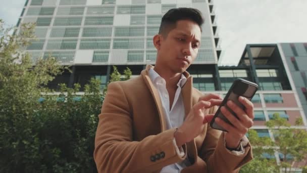 Bej Ceketli Genç Işadamı Sokakta Bankta Oturuyor Cep Telefonunda Daktilo — Stok video