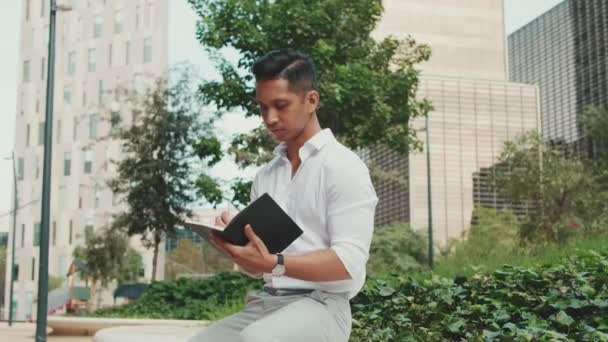 個人的なペーパープランナーでノートを作る若いビジネスマン — ストック動画