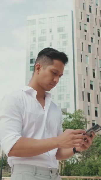 Genç Işadamı Yerinde Dururken Akıllı Telefonuyla Daktilo Kullanıyor — Stok video