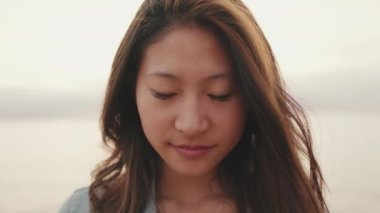 Yaklaş, genç güzel kadın gözlerini açar ve kameraya bakarken gülümser.