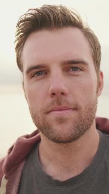 Kumsalda dikilen genç adam, yaklaş.