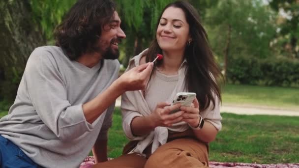 Pareja Enamorada Disfrutando Aperitivos Utilizando Teléfono Móvil — Vídeo de stock