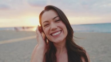 Yaklaş, genç bayan sahilde dururken kameraya gülümse.