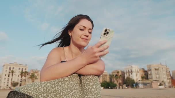 Młoda Kobieta Siedzi Piaszczystej Plaży Używa Telefonu Komórkowego — Wideo stockowe