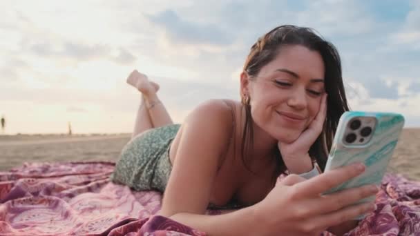 Młoda Uśmiechnięta Kobieta Relaksuje Się Plaży Korzysta Telefonu Komórkowego — Wideo stockowe