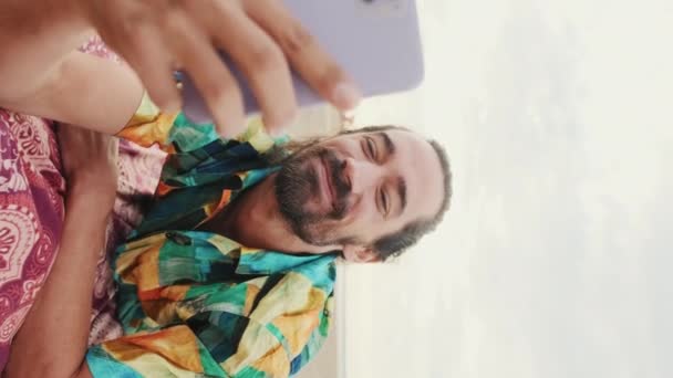 アダルトビデオ 若い幸せな男がビーチで携帯電話を使って — ストック動画