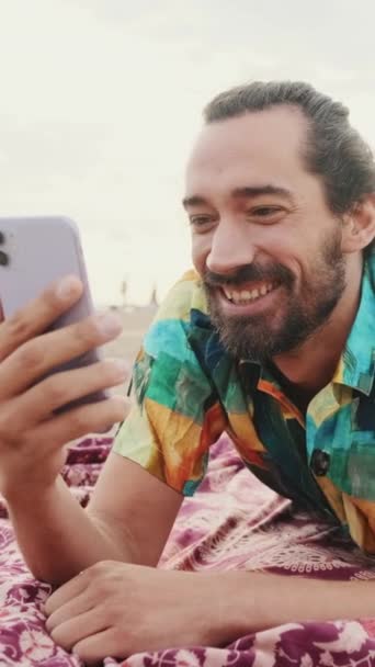 Kumsalda Cep Telefonuyla Video Bağlantısıyla Konuşan Genç Mutlu Bir Adam — Stok video