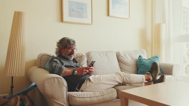 Kanepede Oturan Yaşlı Adam Cep Telefonu Kullanıyor Evdeki Oturma Odasında — Stok video