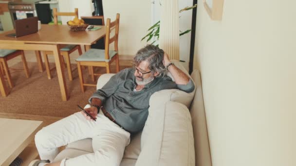 Starší Šťastný Muž Používající Mobilní Telefon Když Sedí Doma Pohovce — Stock video