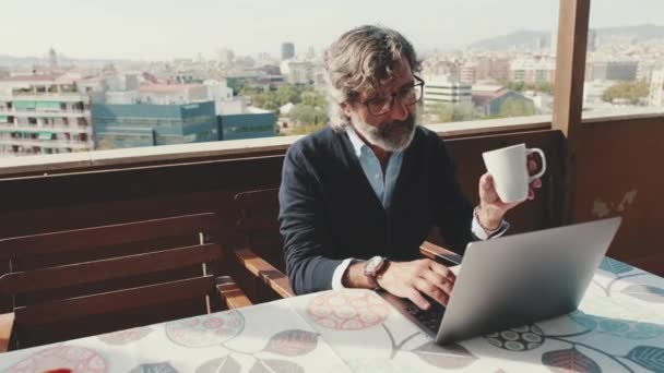 Homem Meia Idade Trabalhando Laptop Bebendo Caneca Enquanto Sentado Varanda — Vídeo de Stock