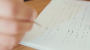 Bir adamın ellerinin yakın plan çekimleri belgeye imza atıyor