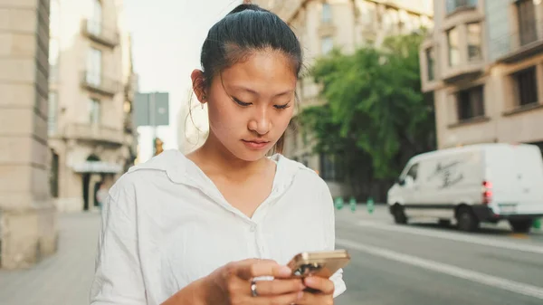 Ung Leende Kvinna Som Använder Mobiltelefon När Hon Står Bredvid — Stockfoto