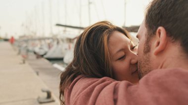 Sevgi dolu çift setin üzerinde otururken öpüşüyor.