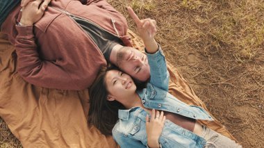 Parkta battaniyeye uzanmış genç bir çift. Yukarıdan görüntüle