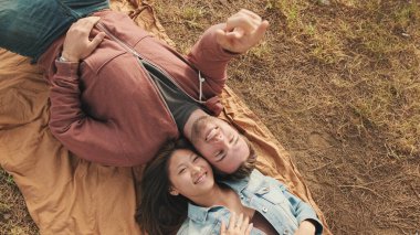 Parkta battaniyeye uzanmış genç bir çift. Yukarıdan görüntüle