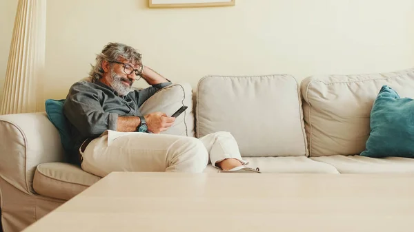 Homem Meia Idade Relaxando Seu Sofá Enquanto Casa Usando Seu — Fotografia de Stock