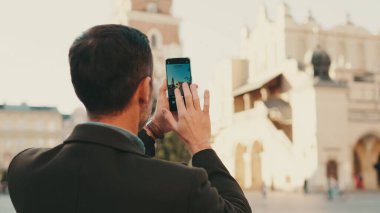 Adam eski şehrin meydanında fotoğraf çekiyor. Arka plan