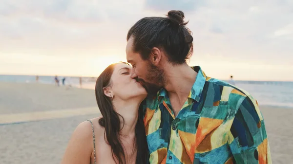 年轻夫妇在日出时分站在海滩上亲吻 — 图库照片