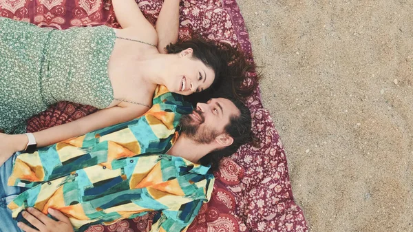 年轻夫妇在海滩上躺在毯子上享受彼此的交流 顶部视图 — 图库照片