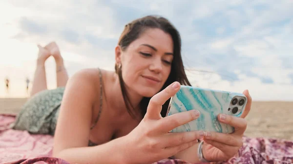 Młoda Uśmiechnięta Kobieta Relaksuje Się Plaży Korzysta Telefonu Komórkowego — Zdjęcie stockowe