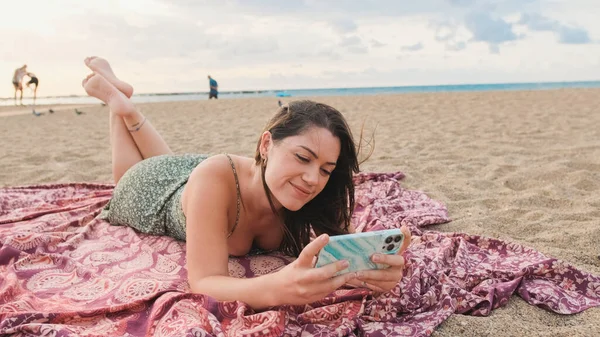年轻的微笑的女人在海滩上放松 用手机 — 图库照片