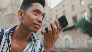 Basamaklarda oturan genç turistlerin yakın plan görüntüleri olan cep telefonundan sesli mesaj göndermeleri.