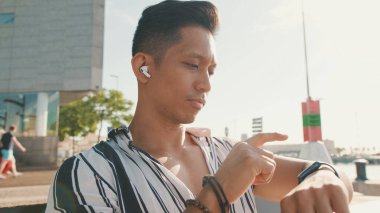 Akıllı saate bakan genç adamın yakın çekimi.