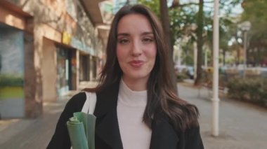 Dışarıda dururken gülümseyen genç bir kadının yakın çekimi.