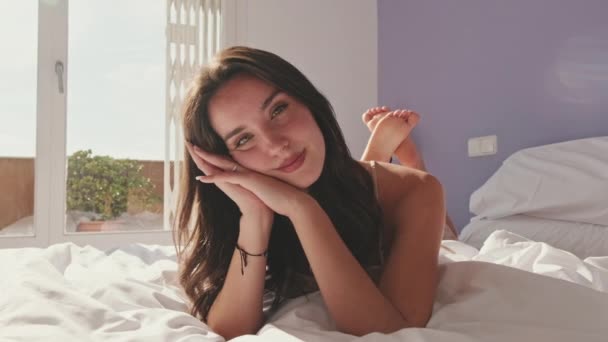 密接な 幸せな女の子ポーズベッドに横たわっ — ストック動画